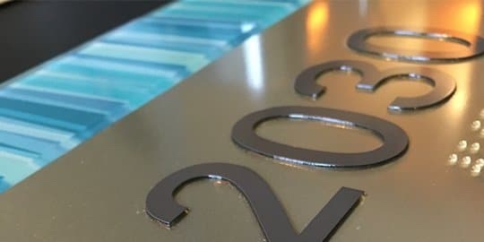ADA braille sign produced with Novacryl AL Series, offering a modern brushed aluminum aesthetic.