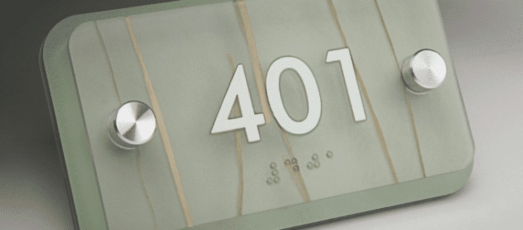 Close-up of an ADA-compliant sign crafted from routing Novacryl photopolymer, featuring crisp edges, tactile text, and a polished finish on a durable PETG base.