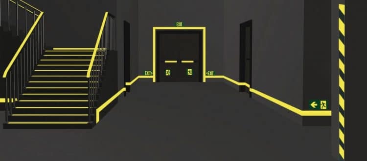 American Permalight photoluminescent signs glowing in the dark, providing clear guidance and visibility in emergency situations.