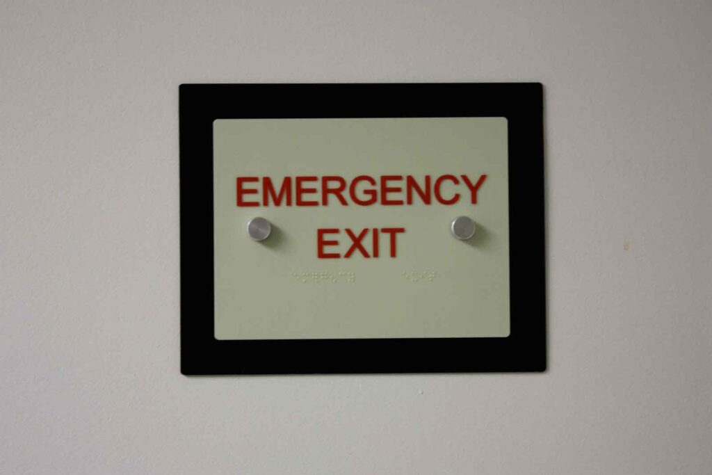 Photoluminescent ADA braille sign made with Novacryl Permaglow Series for enhanced visibility in low light.