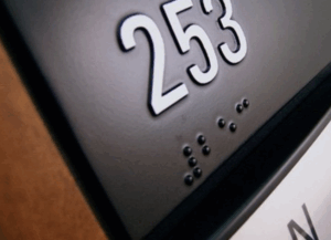 Up-close image of ADA compliant braille on a sign.