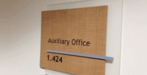 ADA-compliant hospital wayfinding signage featuring tactile room ID signs.