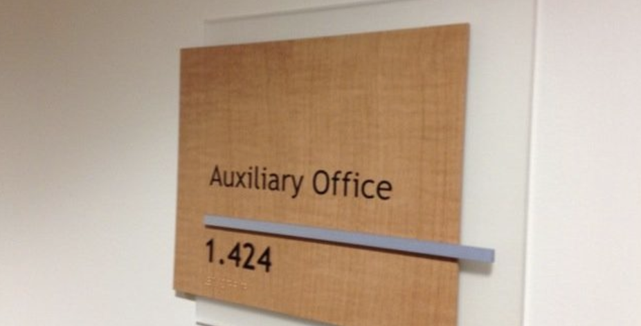 ADA-compliant hospital wayfinding signage featuring tactile room ID signs.