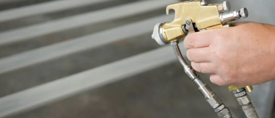 A person applying clear photopolymer spray to a sign, ensuring a durable and protective topcoat.