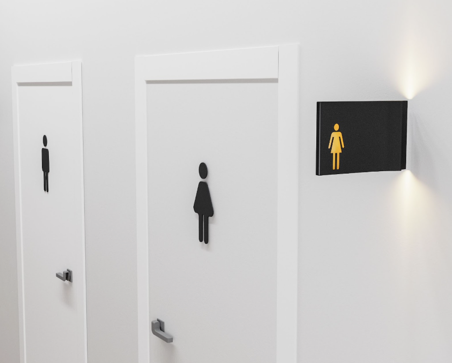 A restroom sign with tactile symbols and raised braille text, providing accessibility for visually impaired individuals. The photopolymer material used in this sign complies with Proposition 65 regulations.