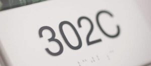 Close-up of tactile braille sign with raised dots.