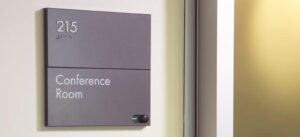 A conference room sign mounted properly according to ADA signage height standards.